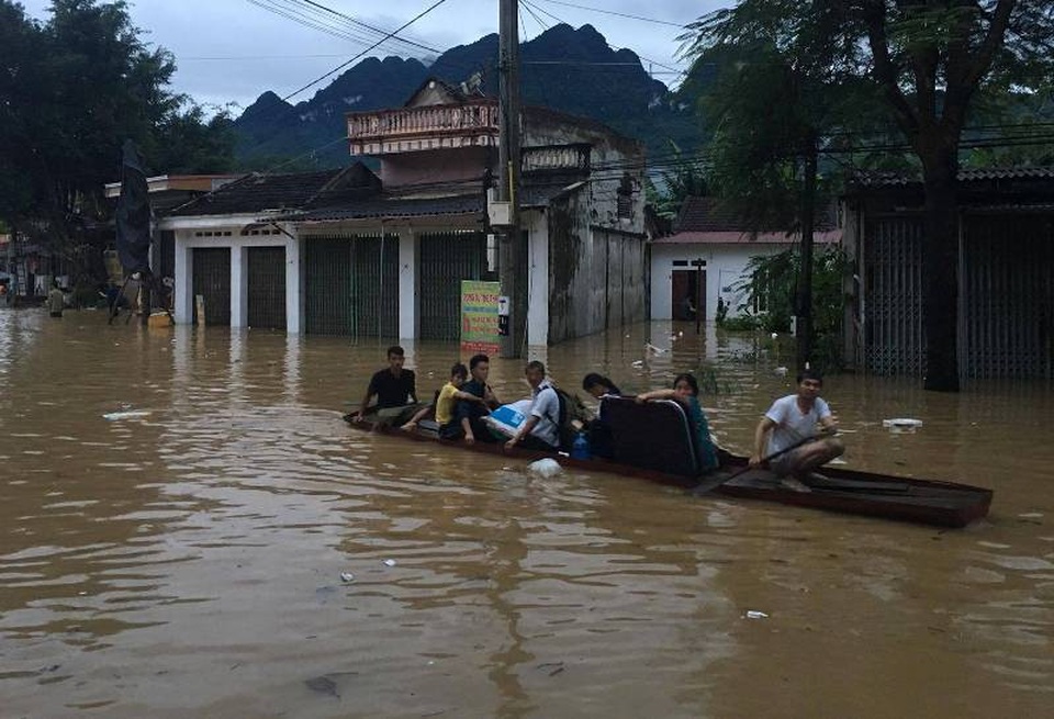Nước lũ nhấn chìm nhiều ngôi nhà, cuốn trôi nhiều tài sản - 11 Do tình trạng ngập lụt nên người dân phải di chuyển trên đường bằng thuyền