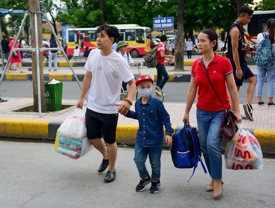 Hình ảnh một gia đình lỉnh kỉnh ba lô, túi xách về quê trong dịp nghỉ lễ kéo dài.