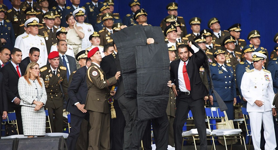 Nicolas Maduro - Tổng thống đi lên từ tài xế xe buýt - 1 Các vệ sĩ bung tấm chắn bảo vệ Tổng thống Maduro khi xảy ra vụ tấn công bằng máy bay không người lái hôm 4/8 (Ảnh: Xinhua)