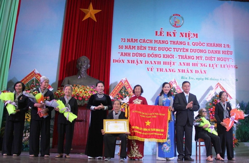Đội quân tóc dài Bến Tre được tuyên dương anh hùng - 1 Chủ tịch Quốc hội Nguyễn Thị Kim Ngân và Bí thư Tỉnh ủy Bến Tre Võ Thành Hạo thay mặt Đảng và Nhà nước trao tặng danh hiệu Anh hùng Lực lượng vũ trang nhân dân cho “Đội quân tóc dài” Bến Tre.