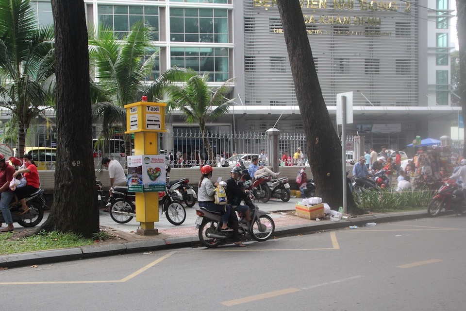 TPHCM: Bến taxi “ế khách” trong ngày đầu khai trương - 1 Điểm đón taxi có trụ báo taxi màu vàng và phần vạch kẻ cho phép dừng xe 2 phút