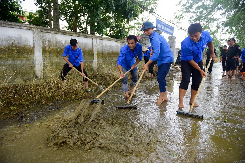 Hàng trăm cảnh sát cứu hỏa, cơ động giúp dân vùng ngập lụt dọn vệ sinh - 6 Cùng với lực lượng cảnh sát cơ động và PCCC, lục lượng thanh niên tình nguyện trên địa bàn xã cũng tham gia giúp người dân dọn vệ sinh.