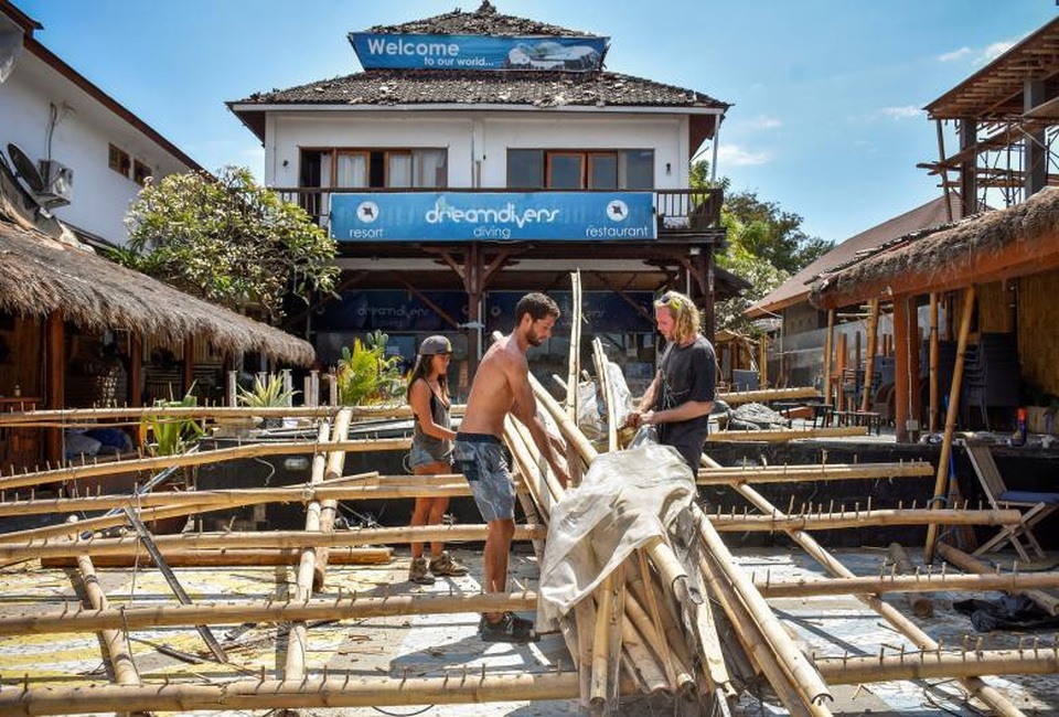 Thảm họa động đất tại Indonesia: Số người chết tăng lên 380 - 6 Người nước ngoài dọn dẹp cửa hàng đổ nát trên đảo Gili Trawangan. (Ảnh: Reuters)