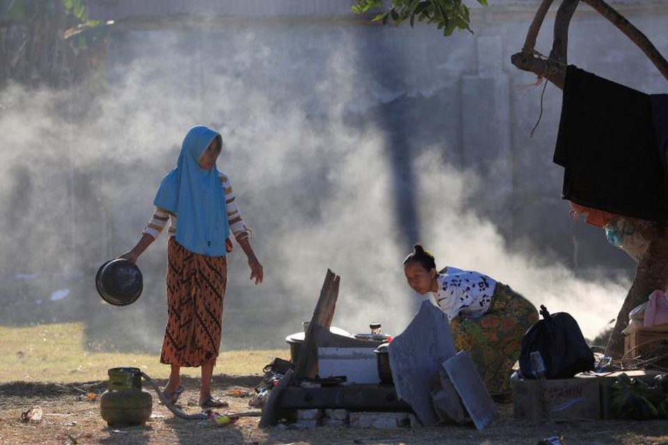 Thảm họa động đất tại Indonesia: Số người chết tăng lên 380 - 8 Người dân dọn dẹp đống đổ nát sau động đất. (Ảnh: Reuters)