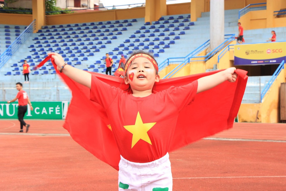 Một cổ động viên nhí xinh đẹp đến sân trước giờ bóng lăn.