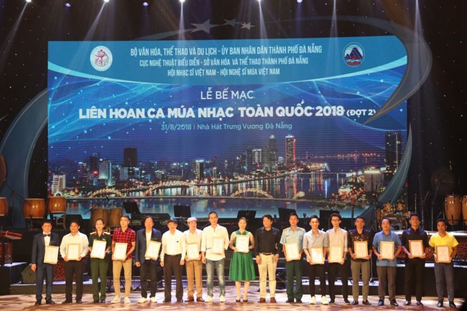 35 HCV được trao tại Liên hoan Ca múa nhạc toàn quốc 2018 đợt 2 - 2 NSND Nguyễn Quang Vinh, Quyền Cục trưởng Cục Nghệ thuật biểu diễn, Phó Trưởng Ban Chỉ đạo Liên hoan và Ông Đặng Việt Dũng, Phó Chủ tịch Ủy Ban Nhân dân Thành phố Đà Nẵng, thành viên Ban chỉ đạo Liên hoan trao Huy chương Vàng cho các tiết mục.