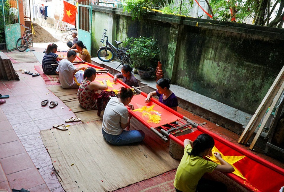 Những bàn tay tài hoa giữ nghề thêu cờ Tổ quốc - 7
Hiện nay, trong làng Từ Vân còn khoảng mười hộ dân theo nghề may cờ thường xuyên, còn lại làm theo thời vụ. Tất cả các công đoạn từ việc làm cờ thủ công ngày xưa so với hiện tại cũng thay đổi. Máy móc công nghiệp ra đời đã khiến việc hoàn thiện 1 lá cờ nhanh hơn trước rất nhiều.