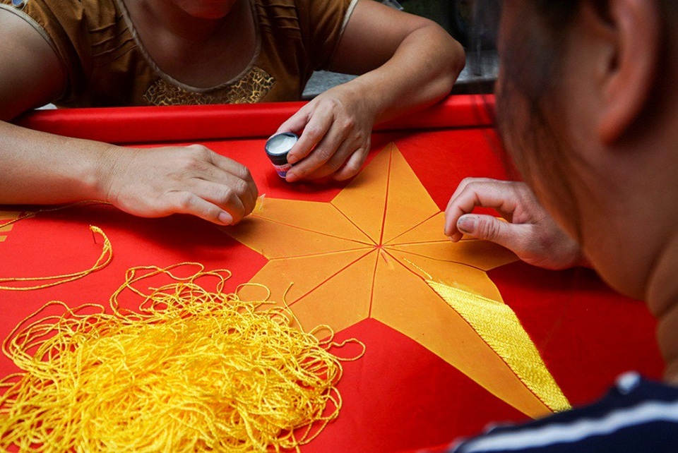Những bàn tay tài hoa giữ nghề thêu cờ Tổ quốc - 8
Nhiều hộ đã sử dụng máy để thêu sao vàng 5 cánh trên cờ, nuy nhiên, chị Nhung vẫn cần mẫn tự tay thêu và thuê thêm thợ để đáp ứng nhu cầu của thị trường. Mặc dù công sức phải bỏ ra nhiều hơn xong với chị, việc làm này đã trở thành một thói quen và niềm yêu thích.