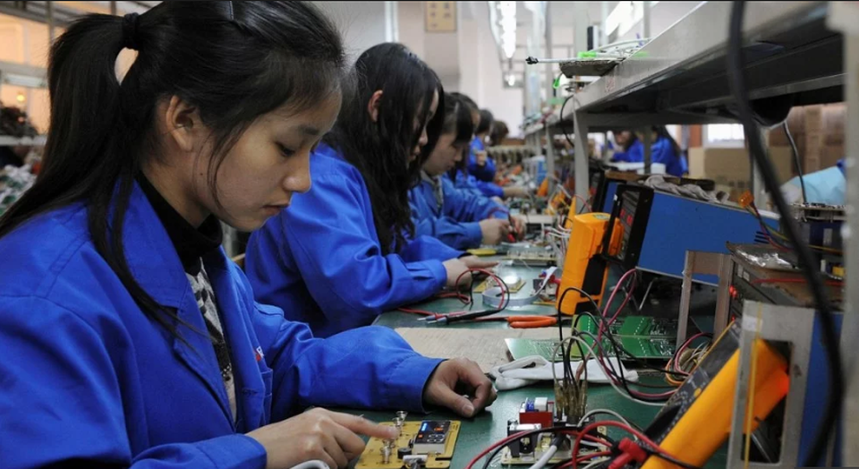 Doanh nghiệp Trung Quốc lao đao vì cuộc chiến thương mại với Mỹ - 1 Các công nhân làm việc trong một xưởng sản xuất tại Trung Quốc (Ảnh: Reuters)