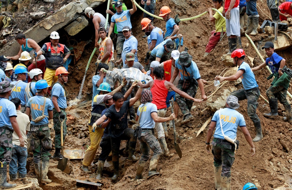 Cứu hộ Philippines cào đất tìm 40 thi thể bị chôn vùi sau siêu bão - 3 Do đất ngấm nước bị nhão nên lực lượng cứu hộ không thể sử dụng các máy móc hạng nặng để tìm kiếm các thi thể bị vùi lấp. Họ phải sử dụng xẻng và dùng tay không để cào đất trong quá trình tìm kiếm các nạn nhân. (Ảnh: Reuters)