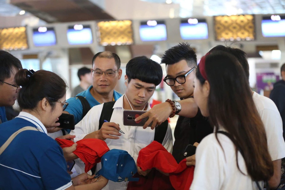 Olympic Việt Nam rời Indonesia, lên chuyên cơ về nước - 16
Người hâm mộ tranh thủ chụp ảnh cùng Công Phượng ở sân bay