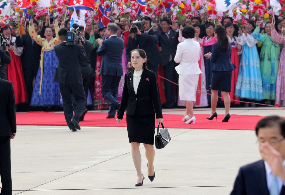 Em gái tất bật tháp tùng ông Kim Jong-un tại thượng đỉnh liên Triều - 2
Những ngày vừa qua, hình ảnh tất bật của em gái ông Kim Jong-un, bà Kim Yo-jong, đã để lại ấn tượng với những người quan sát. Bà gần như xuất hiện tại toàn bộ các sự kiện có sự góp mặt của 2 nhà lãnh đạo, tận tình hỗ trợ khi cần thiết. Bà là người đã tháp tùng ông Kim đón ông Moon ở sân bay sáng ngày 18/9, chỉ đạo trực tiếp hoạt động chào mừng ấn tượng với “rừng” cờ, hoa và những tiếng hô mạnh mẽ. Trong trang mục màu đen gọn gàng, bà đi dọc thảm đỏ, kiểm tra lại dòng người đứng 2 bên đường, kiểm tra kỹ càng mọi thứ một tiếng rưỡi trước khi ông Moon tới. Sau khi máy bay của ông Moon và phu nhân hạ cánh, bà theo sát Tổng thống Hàn Quốc và hỗ trợ Đệ nhất Phu nhân Kim Jung-sook cầm hoa mà bà nhận được từ 2 bé gái Triều Tiên trước đó.
