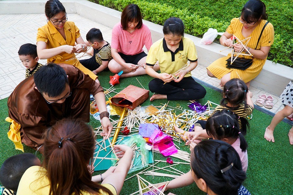 
Cũng tại đây, một số bạn nhỏ được cô giáo và người thân hướng dẫn làm chiếc đèn ông sao truyền thống.
