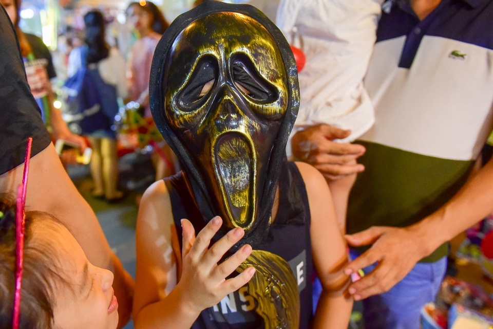 
Bé trai với chiếc mặt nạ kinh dị mua ở phố Hàng Mã.
