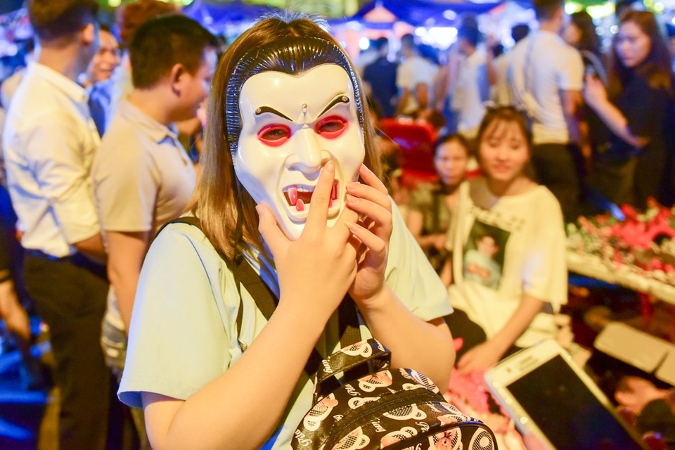 
Một số bạn trẻ đeo mặt nạ kinh dị đi chơi ở phố Hàng Mã khiến không ít người giật mình.

