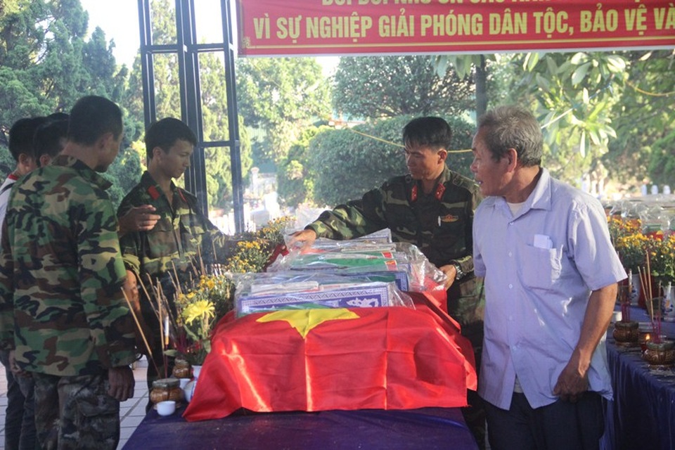 Người thân xúc động đón nhận hài cốt liệt sĩ sau nửa thế kỷ - 5 Lực lượng chức năng chỉnh trang lại cờ Tổ quốc trên các hài cốt.