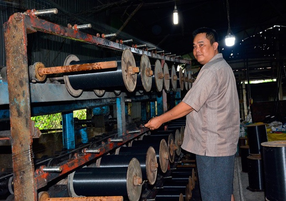 Đi nhặt thứ cả làng vứt đi mà thành tỷ phú - 1 Cơ sở của anh Kiệt có một máy băm, một lò nấu nhựa, hệ thống máy kéo sợi chỉ và 14 máy tạo bánh chỉ lưới thành phẩm, tất cả đều vận hành bằng điện. Ảnh: NQ.