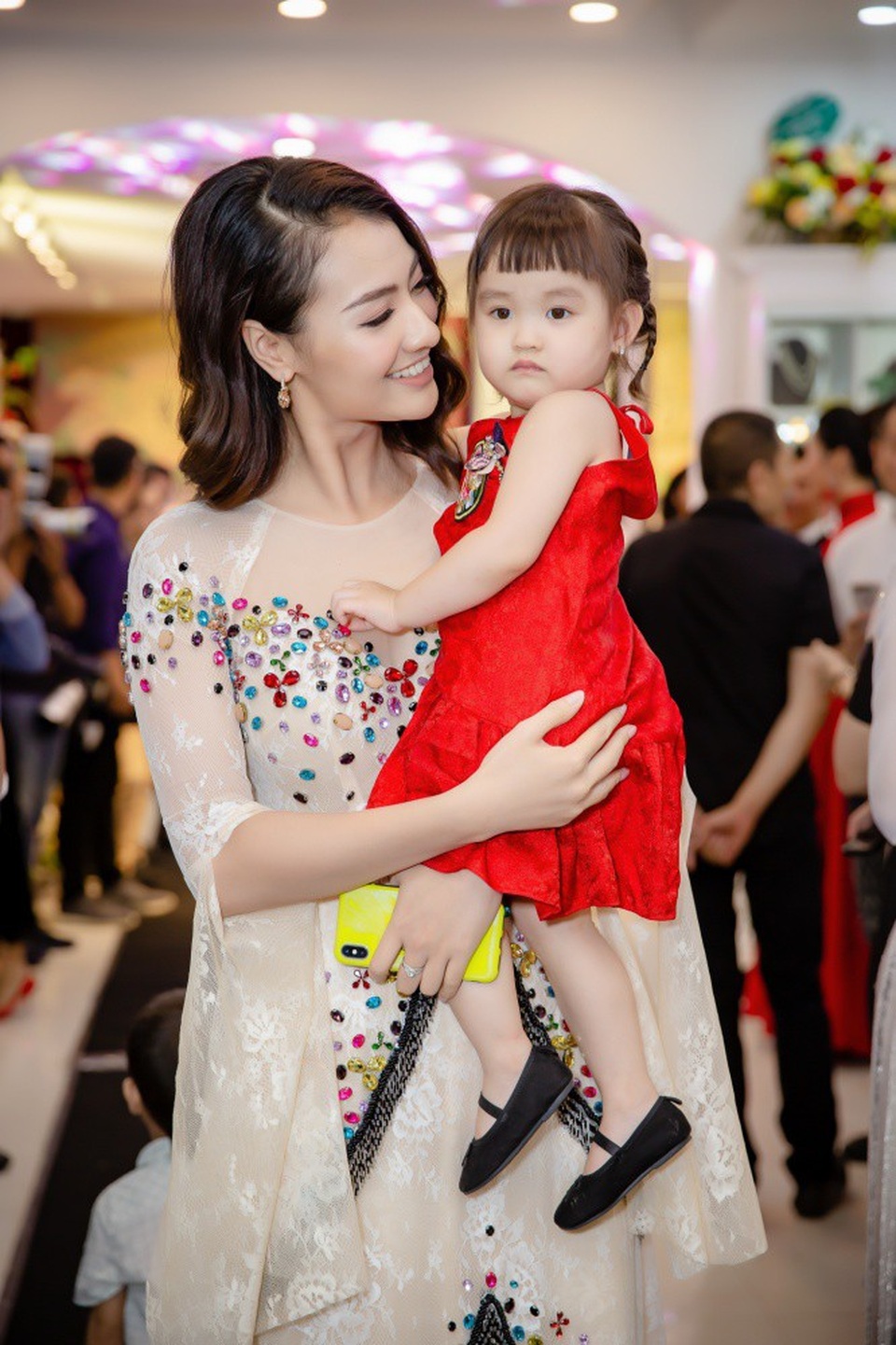 “Người đàn bà đẹp nhất Việt Nam” bất ngờ tái xuất - 13 Người mẫu Hồng Quế gây chú ý khi diện áo dài đính kim sa lấp lánh và bế theo cô con gái đáng yêu. Kể từ khi con gái cứng cáp, Hồng Quế thường xuyên cho bé đi dự sự kiện cùng để chia sẻ niềm đam mê thời trang với mẹ.