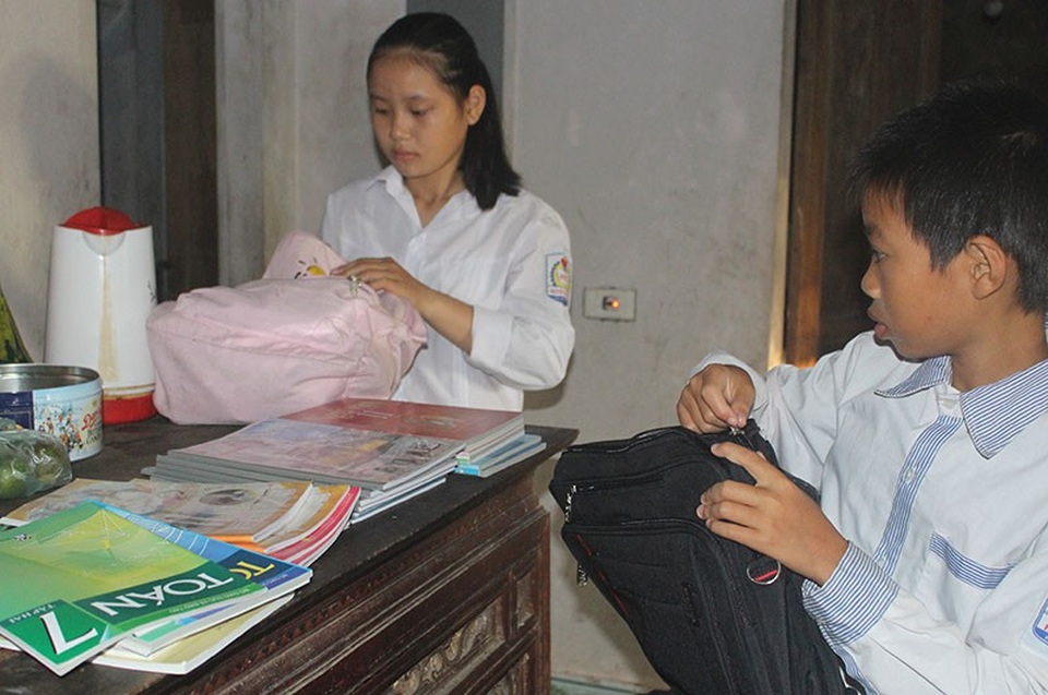 Niềm vui ngày tựu trường của 4 chị em mồ côi bố, mẹ ung thư giai đoạn cuối - 3 Chị em Thương sửa soạn từng tập sách mới mà các em được nhận từ các nhà hảo tâm trước giờ tới trường chào đón năm học mới.