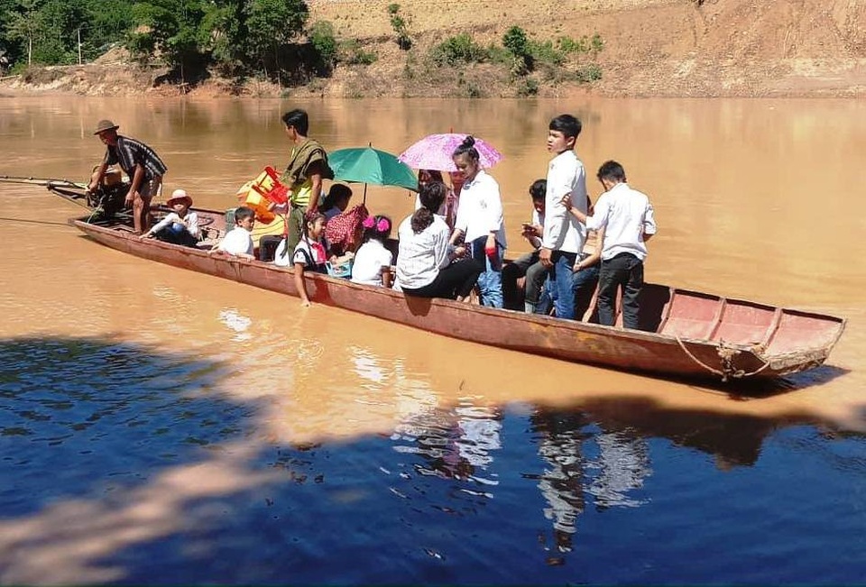 Hàng trăm học sinh đi khai giảng nhờ vì trường bị lũ “xóa sổ” - 6 Học sinh bản Sa Lắng, xã Thanh Xuân đi đò qua sông đến trường khai giảng.