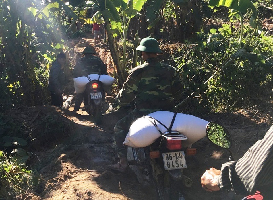 Bộ đội vượt đường lầy chở gạo tiếp tế cho vùng dân bị cô lập sau mưa lũ - 6 Những bao gạo tiếp tế đang dần được các chiến sỹ biên phòng trung chuyển để đến với bà con vùng lũ.