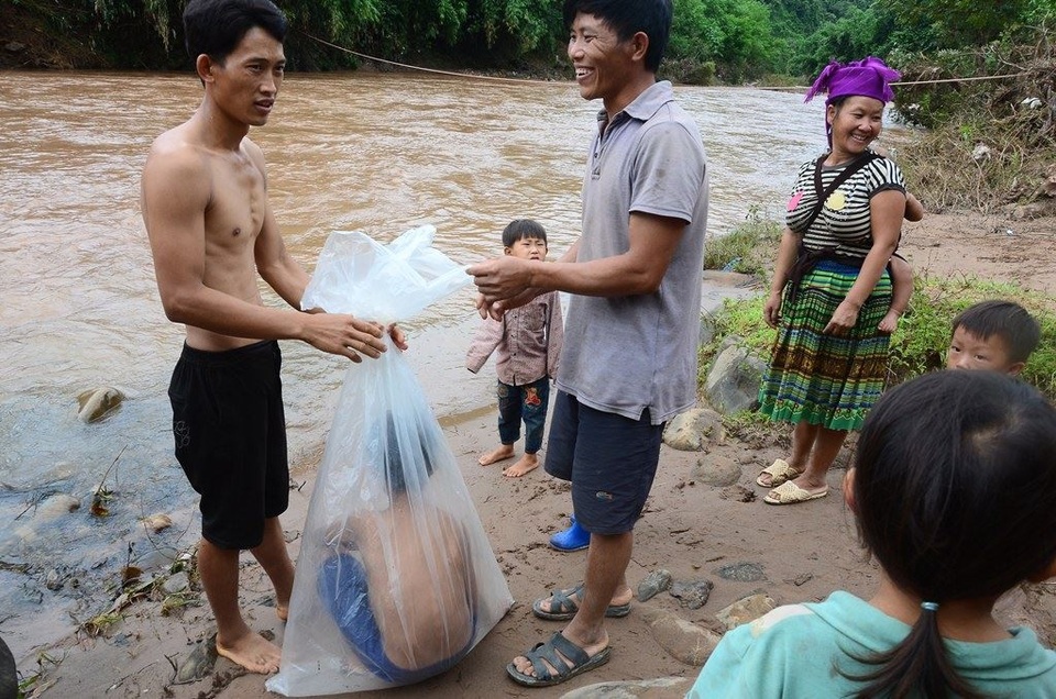 “Đến giáo viên cũng từng chui túi nilon để vượt lũ”! - 2 Vừ A Giống bảo, mỗi trẻ phải ngồi tầm 4- 5 phút trong túi. Các cháu khá sợ và khó thở nhưng không còn cách nào khác. (Ảnh: Đ. Tuấn).