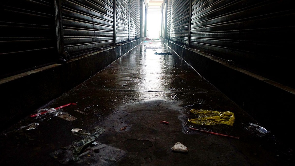 Mái che bị thủng khiến nước mưa đổ xuống ngấm ướt hết sàn chợ.