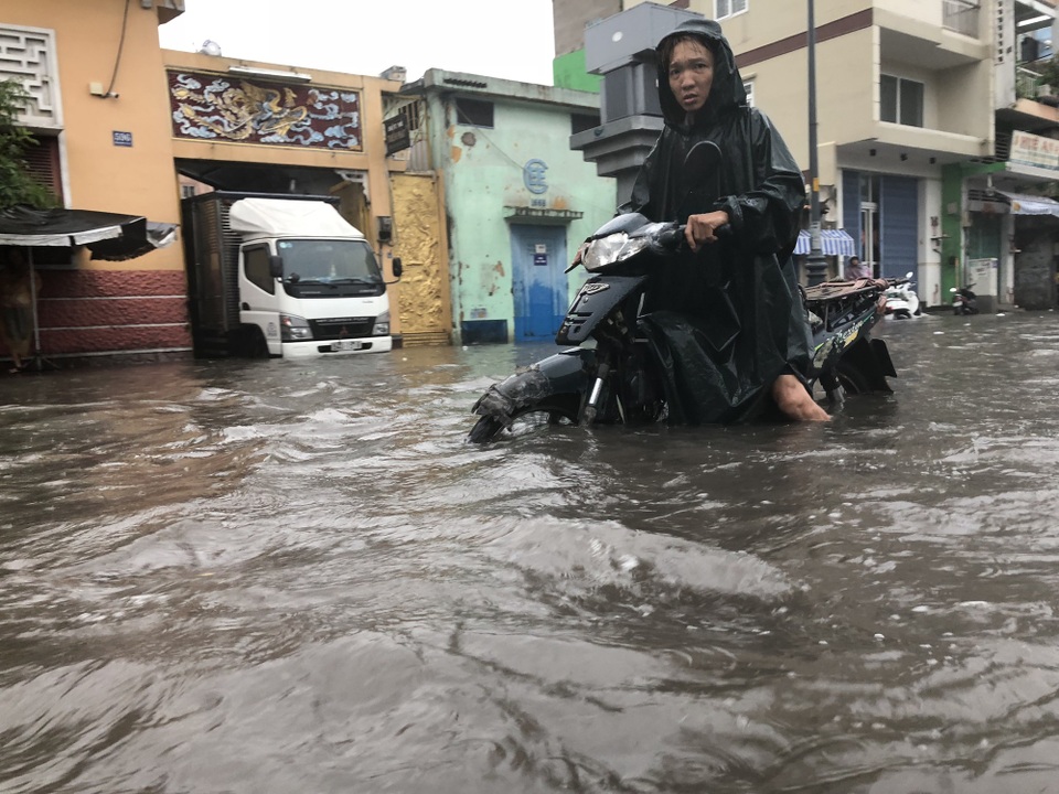 Một người đàn ông cố đẩy xe qua điểm ngập