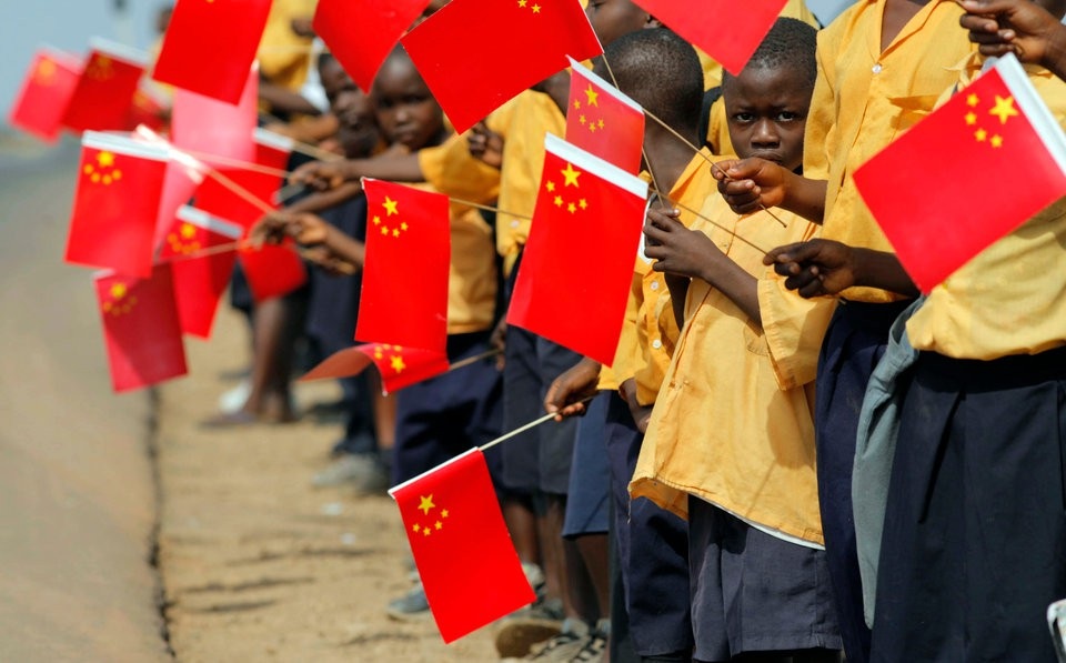 Trung Quốc rót hàng tỷ USD vào châu Phi: Sự lựa chọn khôn ngoan? - 2 Trẻ em Liberia cầm cờ chào đón trong chuyến thăm của lãnh đạo cấp cao Trung Quốc (Ảnh: Reuters)