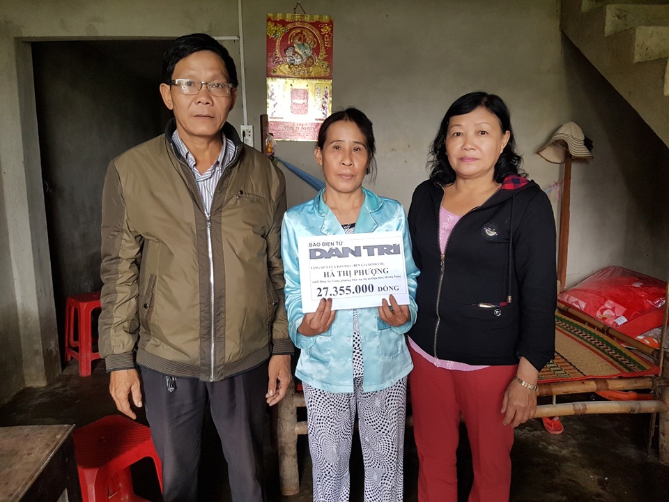 Đại diện lãnh đạo phường Điện An trao quà của bạn đọc Dân trí đến bà Phượng