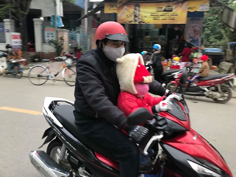 Trẻ em miền Trung hóa... ninja tới trường trong giá rét - 17
Hai cha con ở TP Đông Hà vượt rét.
