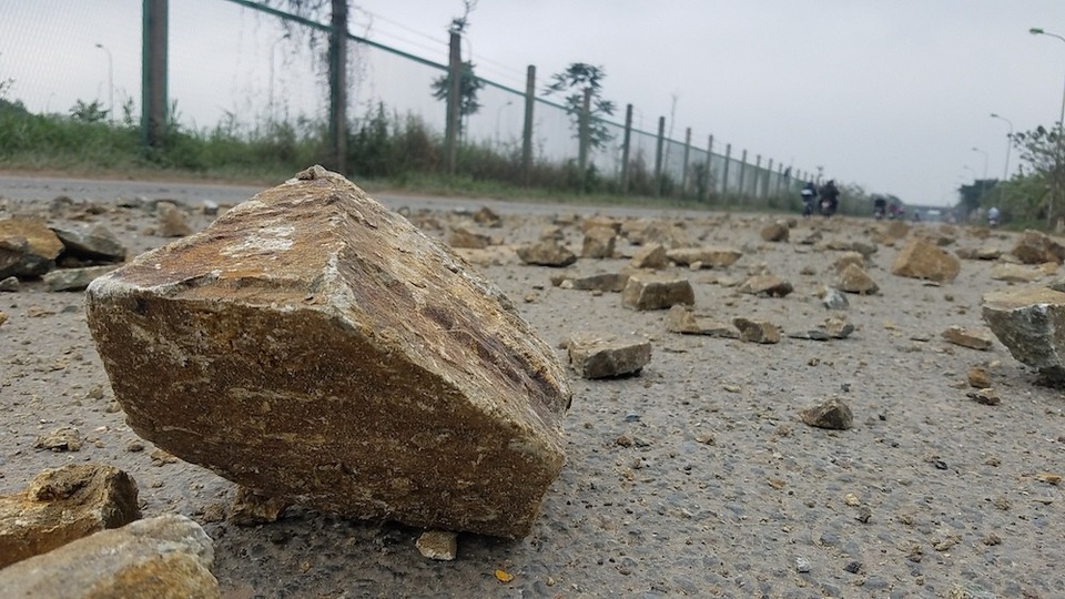 Đá hộc rơi vãi đầy đường Đại lộ Thăng Long - 1
Chiều 6/2, đường gom Đại lộ Thăng Long đoạn gần cầu vượt Phương Bản xuất hiện rất nhiều đá hộc rơi vãi trên lòng đường, kéo dài cả trăm mét.