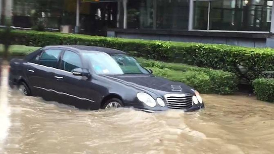 Singapore: Phố thành “sông” sau mưa lớn - 2
Mực nước ở một số khu vực thậm chí lên tới đầu gối người đi đường, ngập ngang thân xe hơi. (Ảnh: CNA)