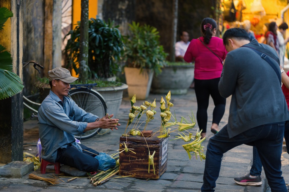 Du khách thích thú với những mặt hàng lưu niệm thủ công như những cánh hoa, những con châu chấu gấp bằng 