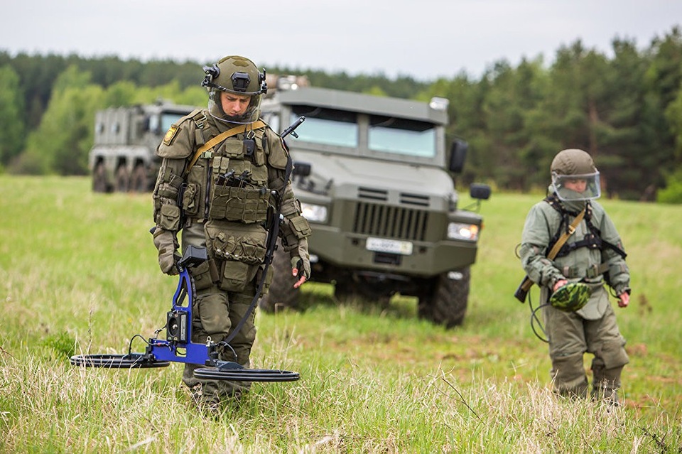 Tại chiến trường Syria, các chuyên gia rà phá bom mìn của Nga đã xử lý hơn 6.500 hec-ta đất, 1.500 tuyến đường, hơn 17.000 ngôi nhà và công trình, vô hiệu hóa hơn 100.000 chất nổ và hơn 30.000 thiết bị nổ cải tiến (IED). Trong ảnh: Công binh Nga diễn tập rà phá bom mìn.