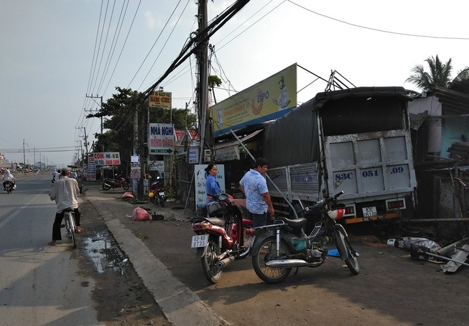 Chiếc xe tải mất lái leo lên lề, đâm vào mái hiên nhà của dân