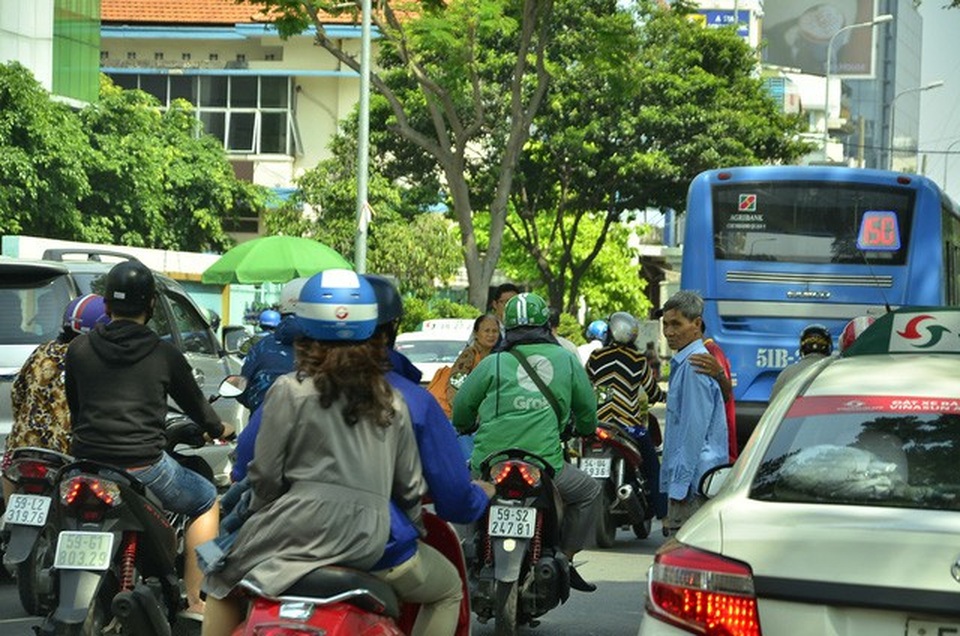 Nhiều người băng qua đường trước đầu hàng loạt phương tiện ở Bệnh viện Bình Dân