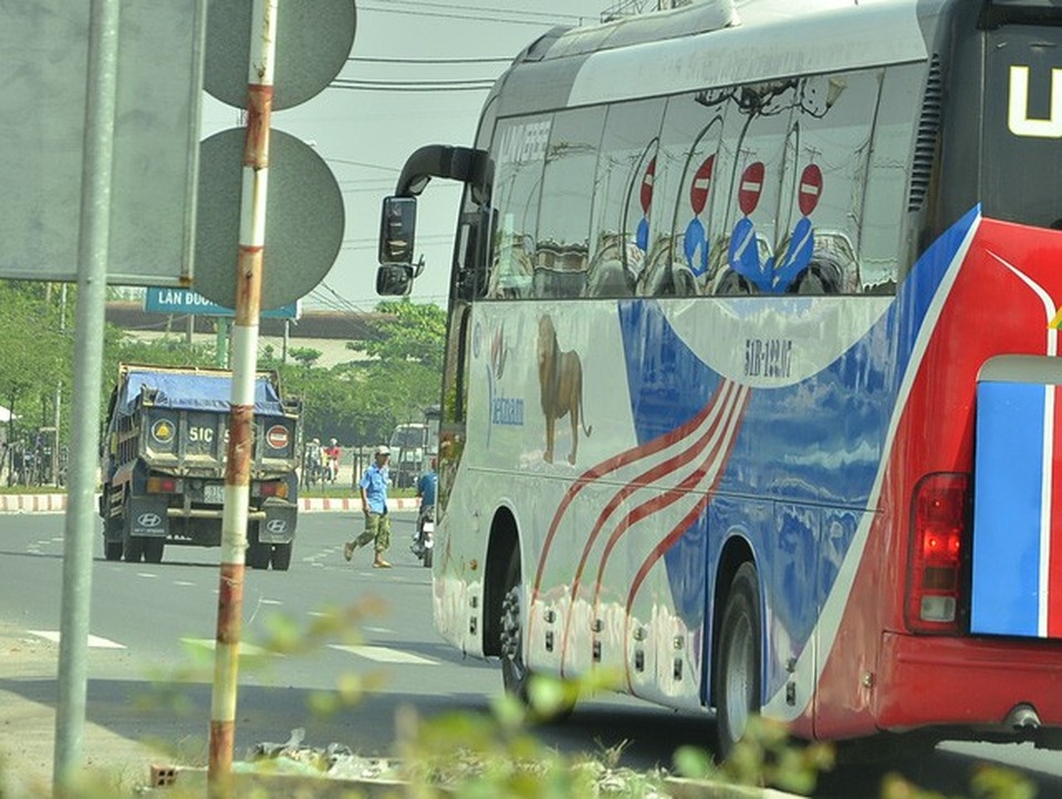 Một người đàn ông cố băng qua đường trước đầu xe khách