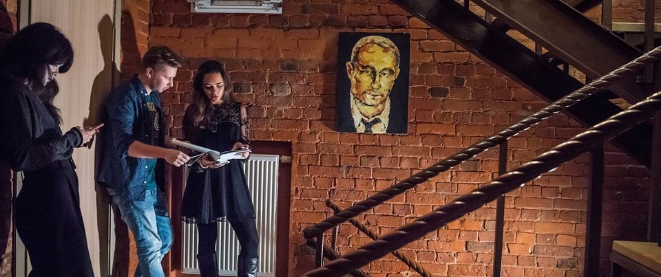 Chân dung Tổng thống Putin được treo trên tường tại văn phòng của Project Network ở Moscow (Ảnh: NBC)