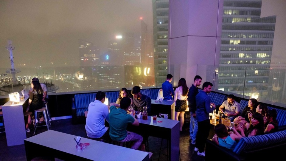 Đón năm mới ở quán bar sang chảnh với giá 1 bitcoin, tương đương 13.000 USD - 1 Các khách hàng thưởng thức rượu tại quán bar Skyline và ngắm nhìn thành phố đón năm mới từ trên cao. (Nguồn: AFP)