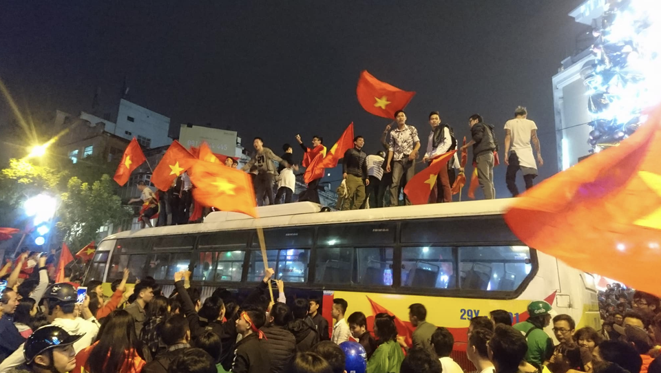 Đêm trắng sau chiến thắng lịch sử của U23 Việt Nam - 8
Xe buýt bị mắc kẹt giữa dòng người đã trở thành sân khấu bất đắc dĩ cho nhiều người đứng phất cờ...