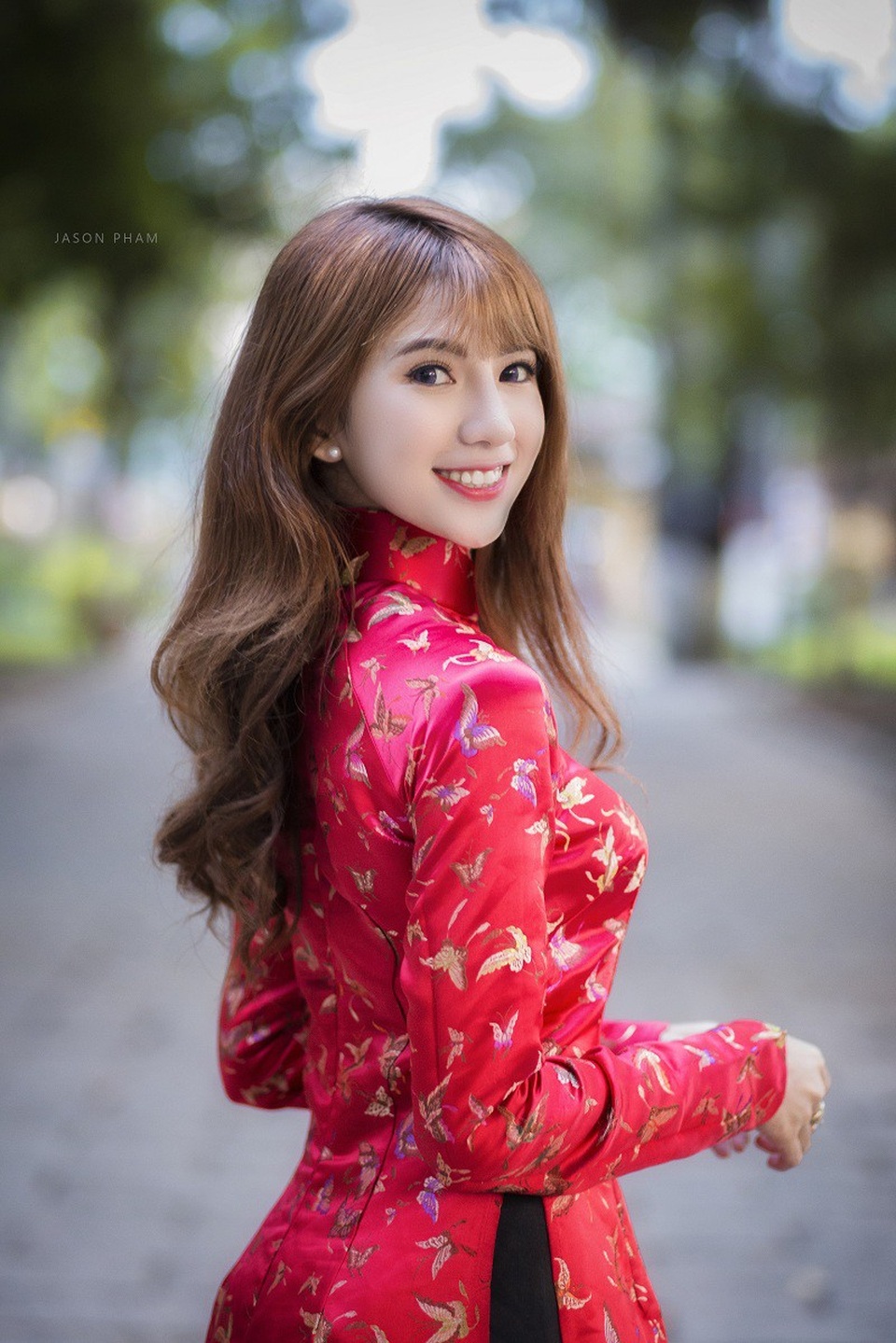 Thiếu nữ Sài Gòn duyên dáng trong tà áo dài chờ đón Xuân sang - 6 Trong bộ áo dài đỏ, Hậu Giang dịu dàng thả dáng cùng nụ cười duyên, trên tay là phong bao lì xì và hoa mai vàng khoe sắc.