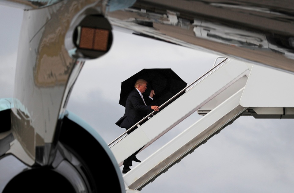 Tổng thống Trump che ô một mình, phu nhân và con trai đầu trần - 1 Theo Dailymail, Tổng thống Donald Trump cùng phu nhân Melania và con trai Barron đã dành ngày nghỉ cuối tuần trước ở khu nghỉ dưỡng Mar-a-Lago của gia đình ông ở West Palm Beach, bang Florida, Mỹ. (Ảnh: Reuters)