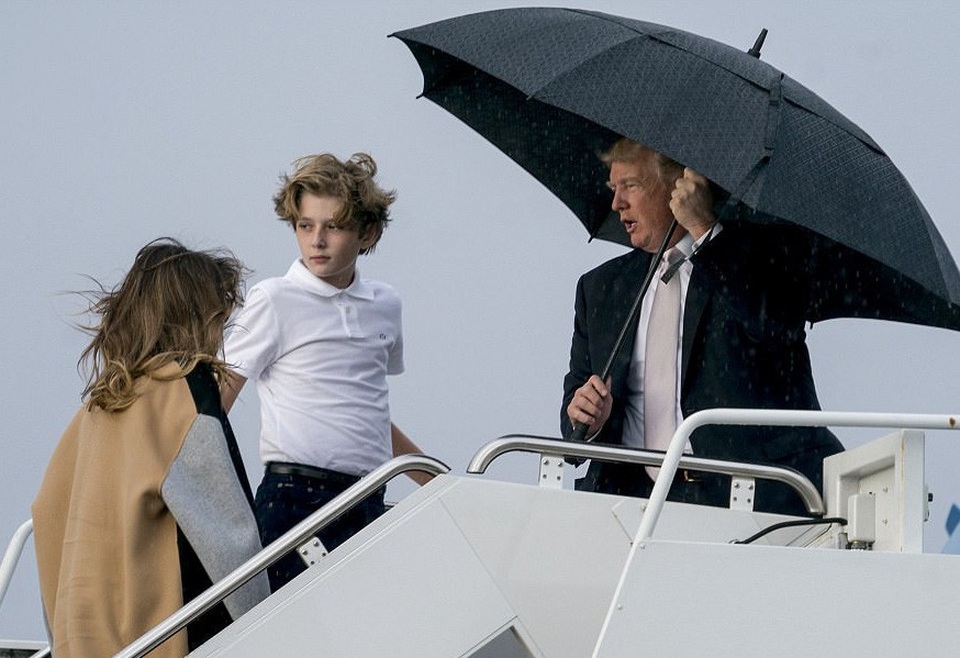 Tổng thống Trump che ô một mình, phu nhân và con trai đầu trần - 4 Trong khi đó, Đệ nhất phu nhân Melania, 47 tuổi, và con trai Barron, 11 tuổi, để đầu trần và bước ngay sau Tổng thống Trump. (Ảnh: Dailymail)