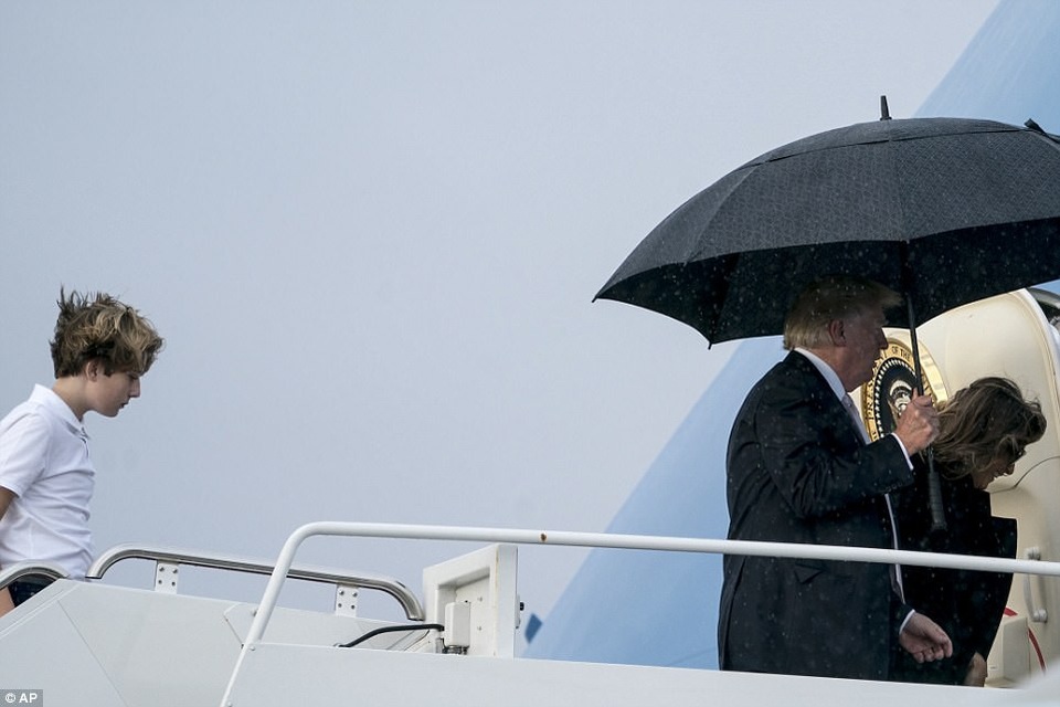 Tổng thống Trump che ô một mình, phu nhân và con trai đầu trần - 6 Một bức ảnh cho thấy Tổng thống Trump dường như mang cả ô vào phía trong khoang máy bay rồi mới gập lại để không bị ướt. (Ảnh: AP)