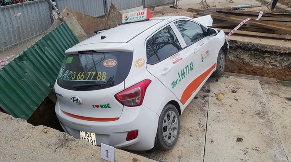 Giải cứu xe taxi lao xuống hố công trình - 1 Chiếc taxi lọt hẳn xuống hố