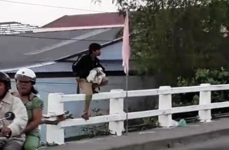 Nam thanh niên tay cầm dao, tay bế em bé đòi nhảy cầu tự tử - 2