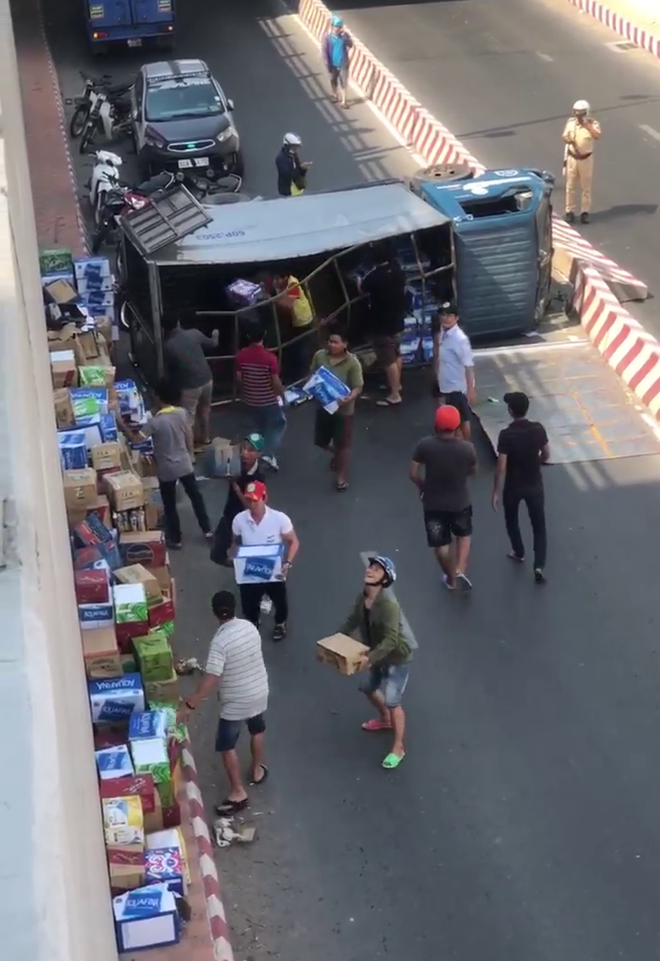 Người dân giúp tài xế gom hàng trăm thùng nước khi xe tải lật - 2 Người dân giúp tài xế gom hàng trăm thùng nước khi xe tải lật - 2