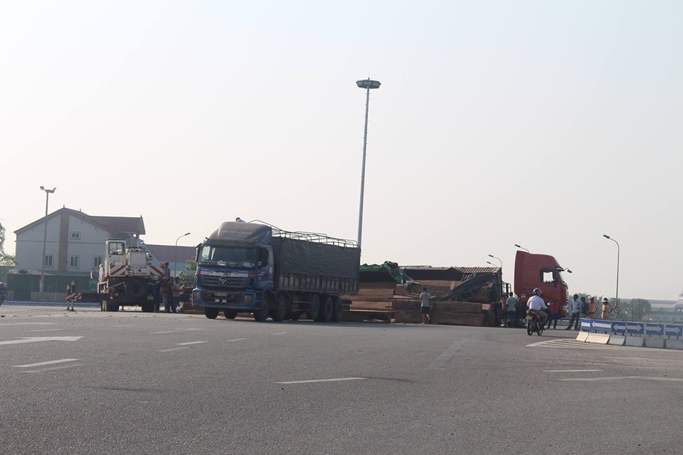 Xe đầu kéo lật nghiêng, hàng chục m3 gỗ đổ tràn trên quốc lộ - 4