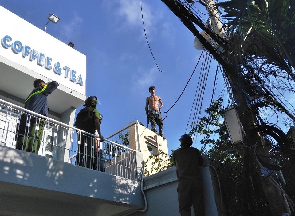 3.jpg Nam thanh niên trèo lên nóc nhà dân cố thủ